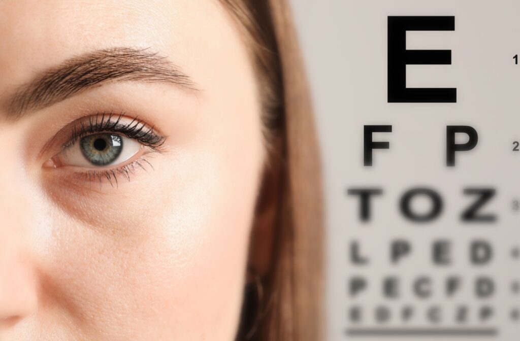 A close-up image of a person's eye with a Snellen chart with letters displayed as the backdrop