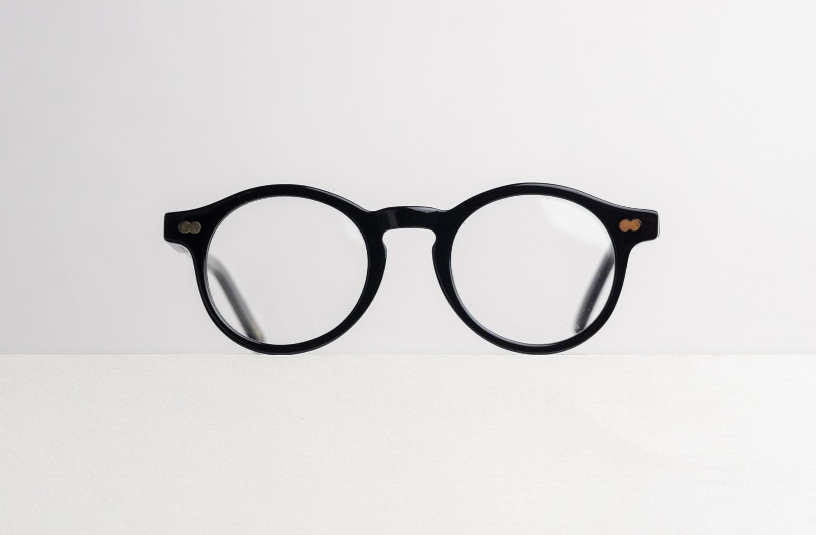 A close up of a pair of glasses sitting on a white surface.
